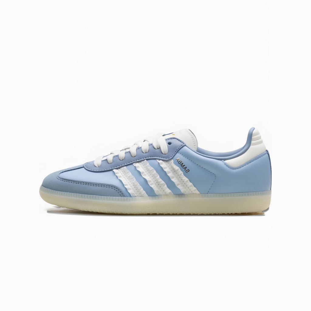 A light blue Adidas Samba sneaker with white three-stripes, white laces, and a white heel tab, set against a plain white background.