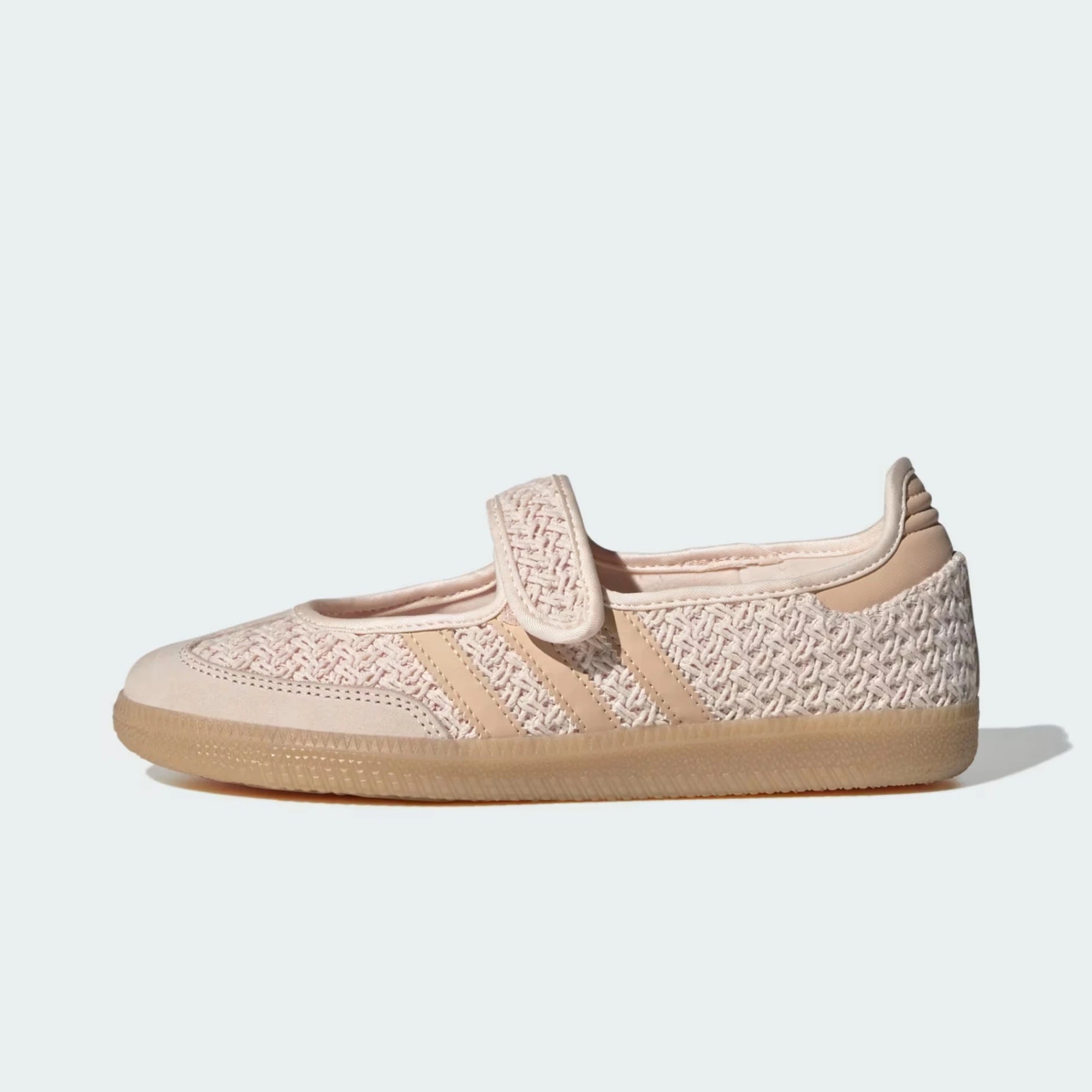 A single Adidas samba jane sneaker in a light beige and cream colorway, featuring a woven knit upper, a hook-and-loop strap closure, and a gum rubber sole, shown against a light gray background.