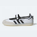 A white Adidas samba jane ruffle pack sneaker with black stripes, a black hook-and-loop strap closure, and a translucent off-white sole, shown from a side profile on a light gray background.