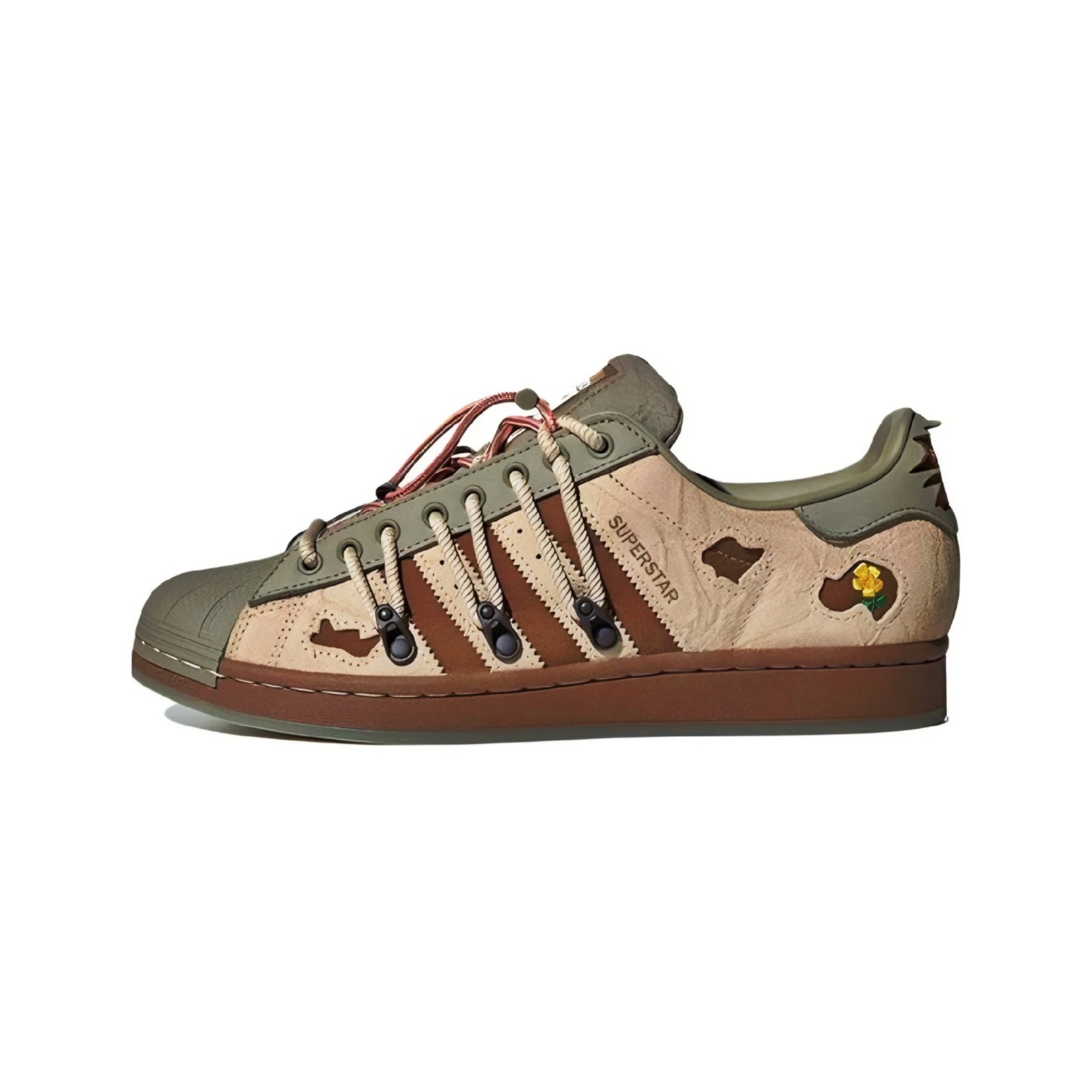 Low-top Adidas Superstar melting madness in beige, brown, and olive green. It features a beige suede upper with brown leather overlays, olive green toe cap and heel, brown laces, and a brown rubber sole.