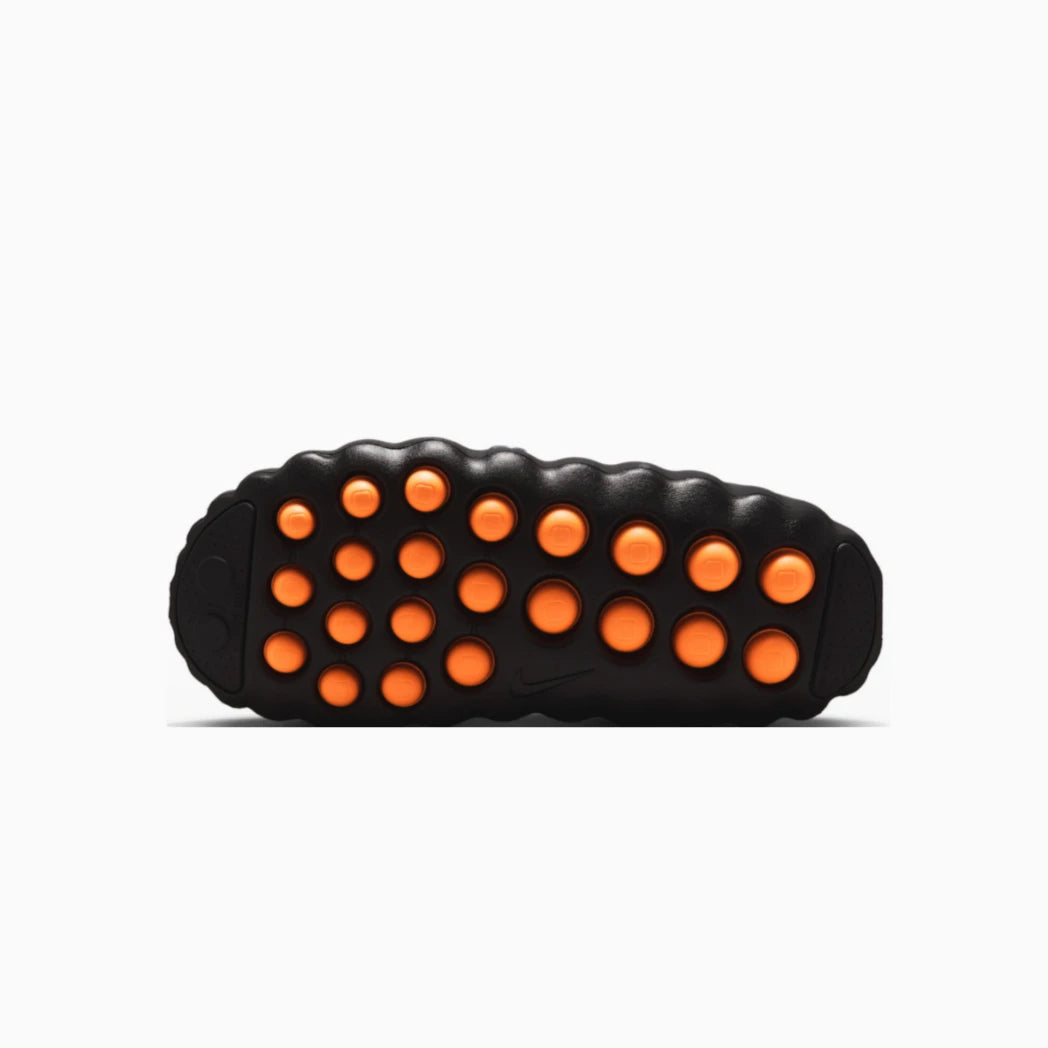 Black Nike Mind slip on undersole image. Featuing orange silicone foot massager pads, shown from a top-down view.