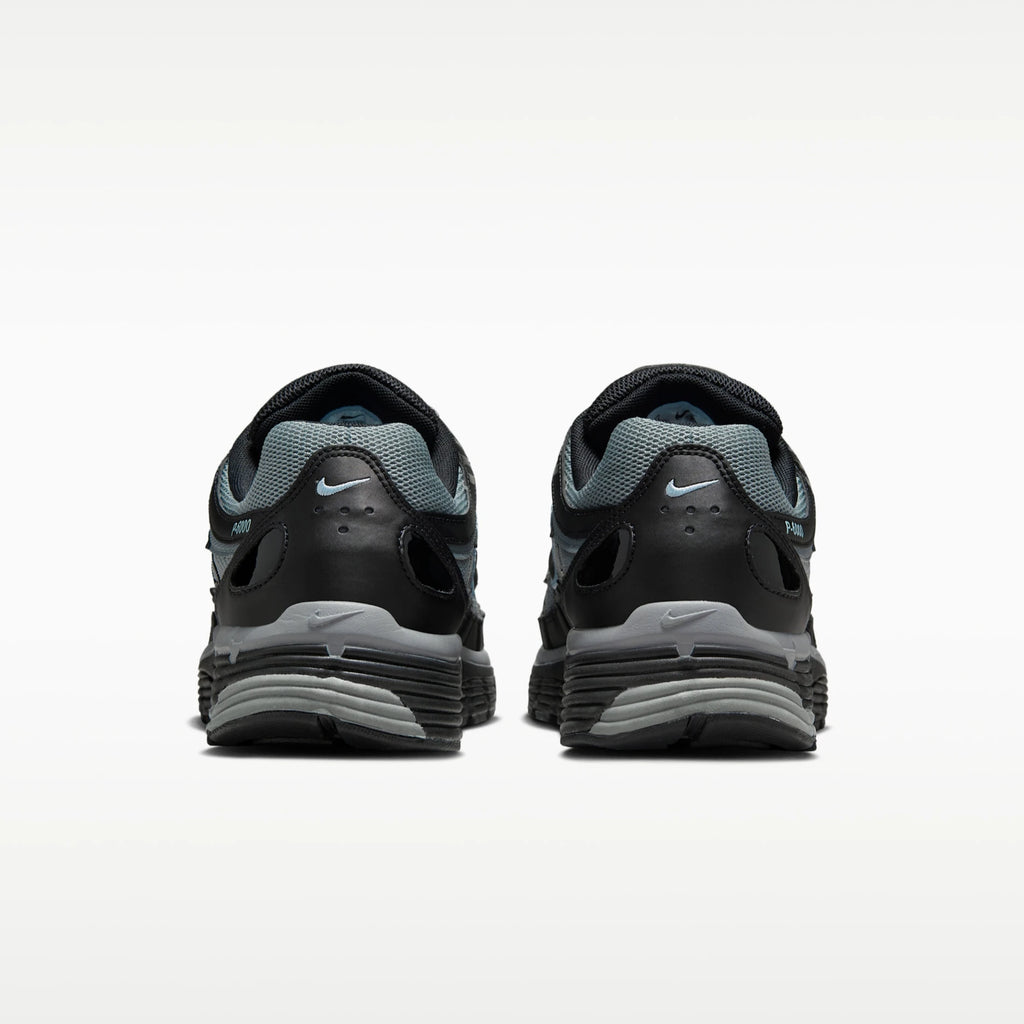 A pair of Nike P6000 running shoes shown from the rear, featuring a black and gray design with a light blue Nike Swoosh on the heel and tongue.