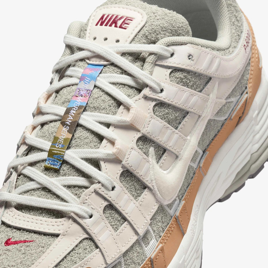 Gray Nike P6000 sneaker with a colorful tag on a white background