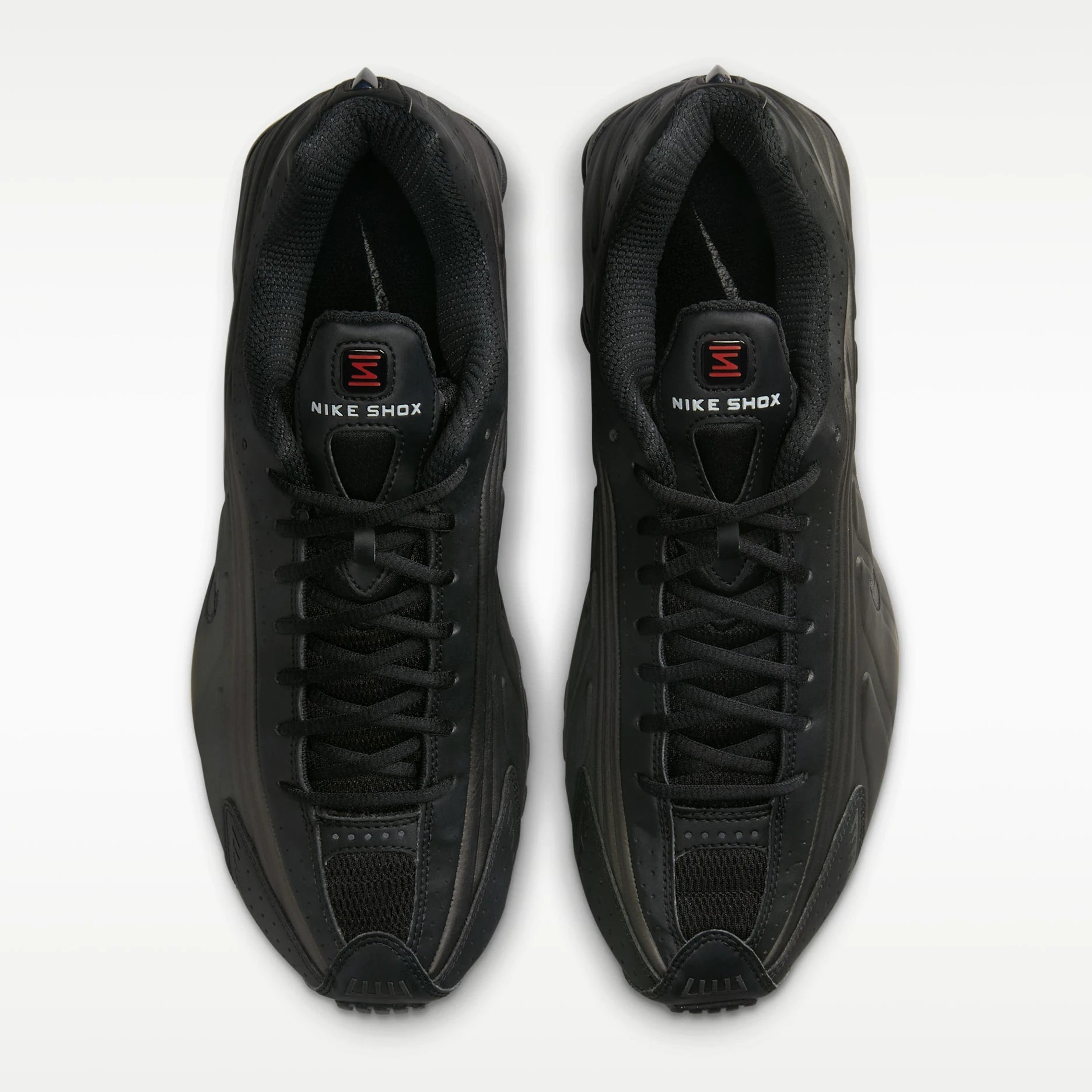 Pair of black Nike Shox sneakers on a white background
